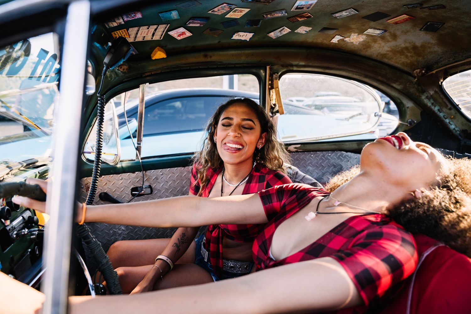 Vintage car interior photoshoot with red plaid shirt styling.
