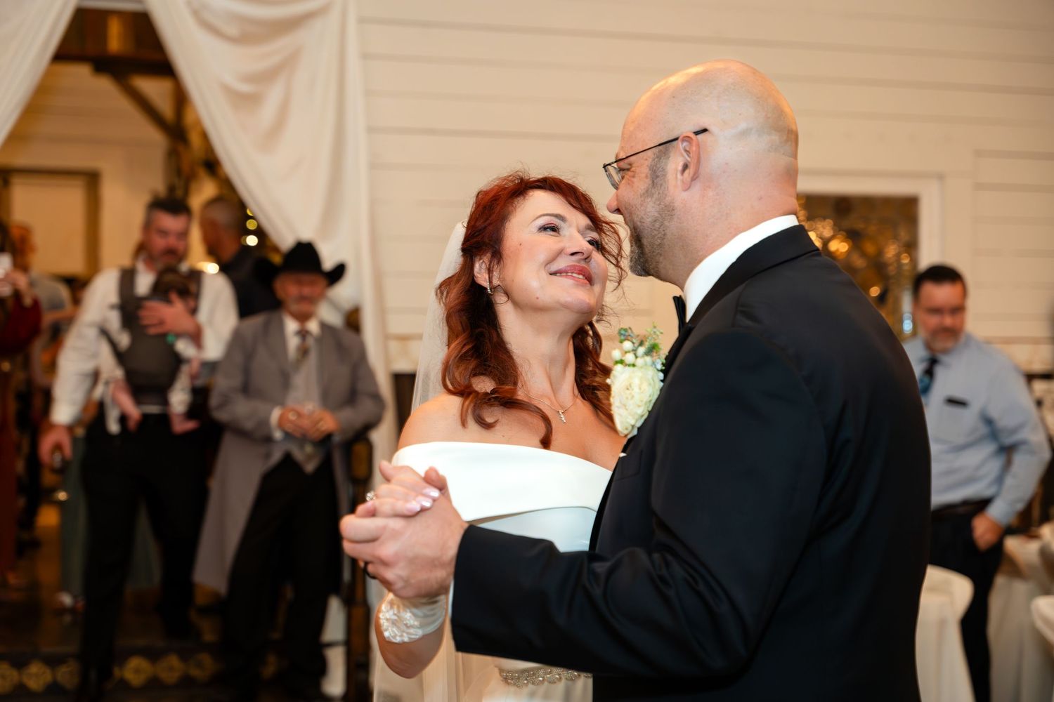 A couple shares their first dance at an indoor wedding reception.