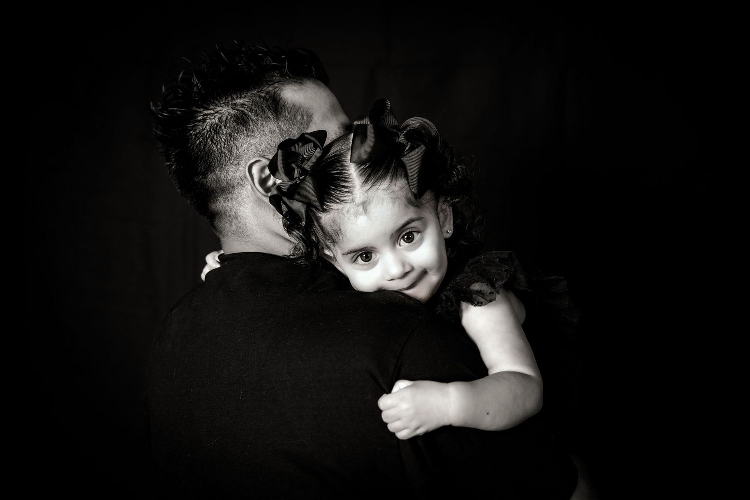 Dramatic black and white portrait showing loving embrace between parent and child.