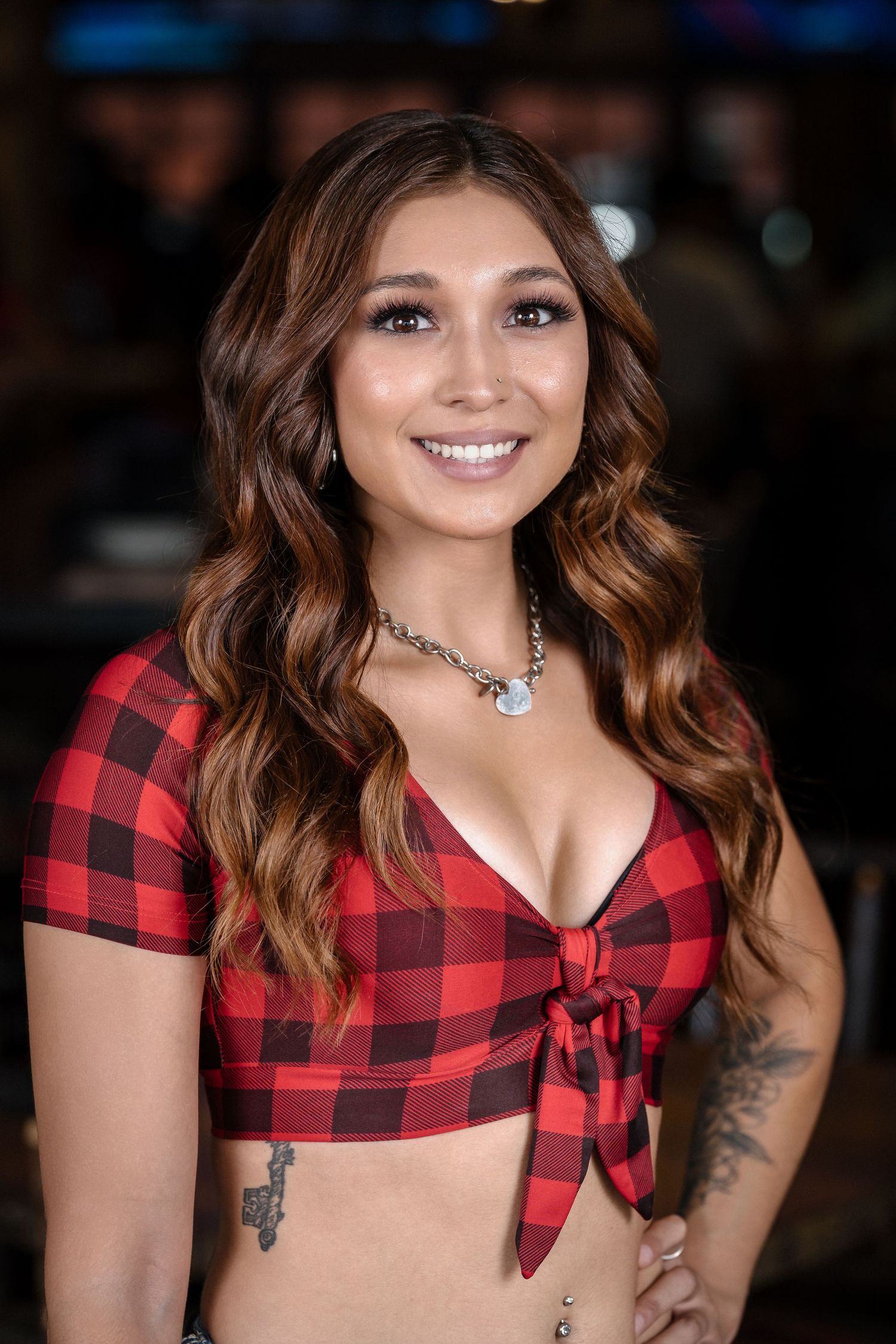 Restaurant staff wearing red buffalo plaid crop top with silver jewelry.