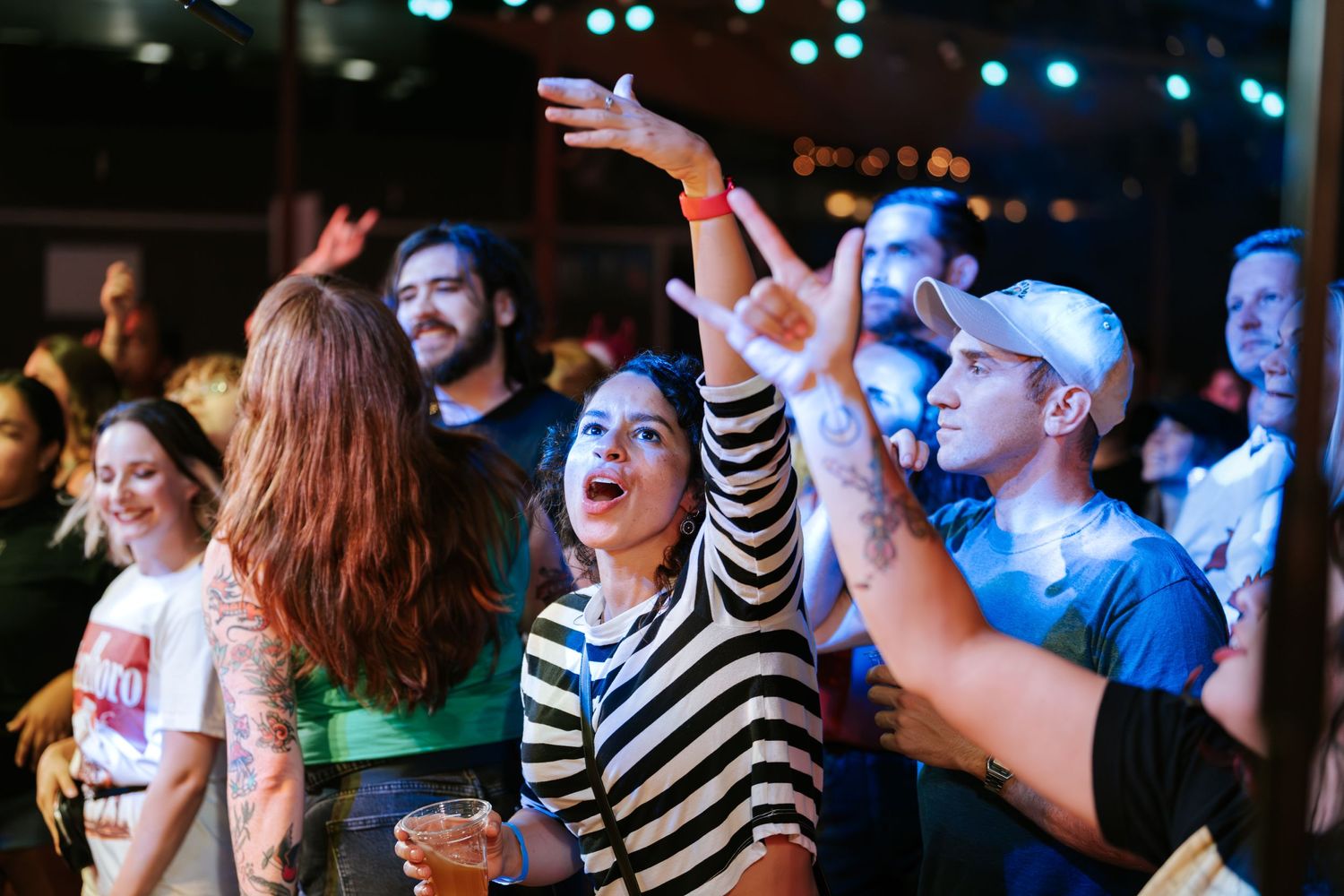 Enthusiastic crowd dancing and cheering during live music performance.