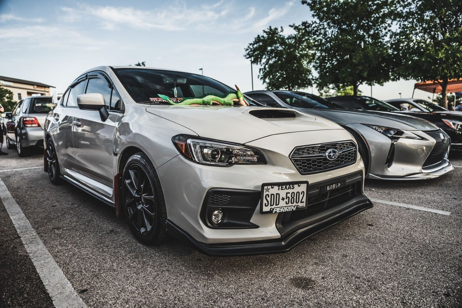 Silver Subaru WRX STI with custom body modifications parked at a car show.