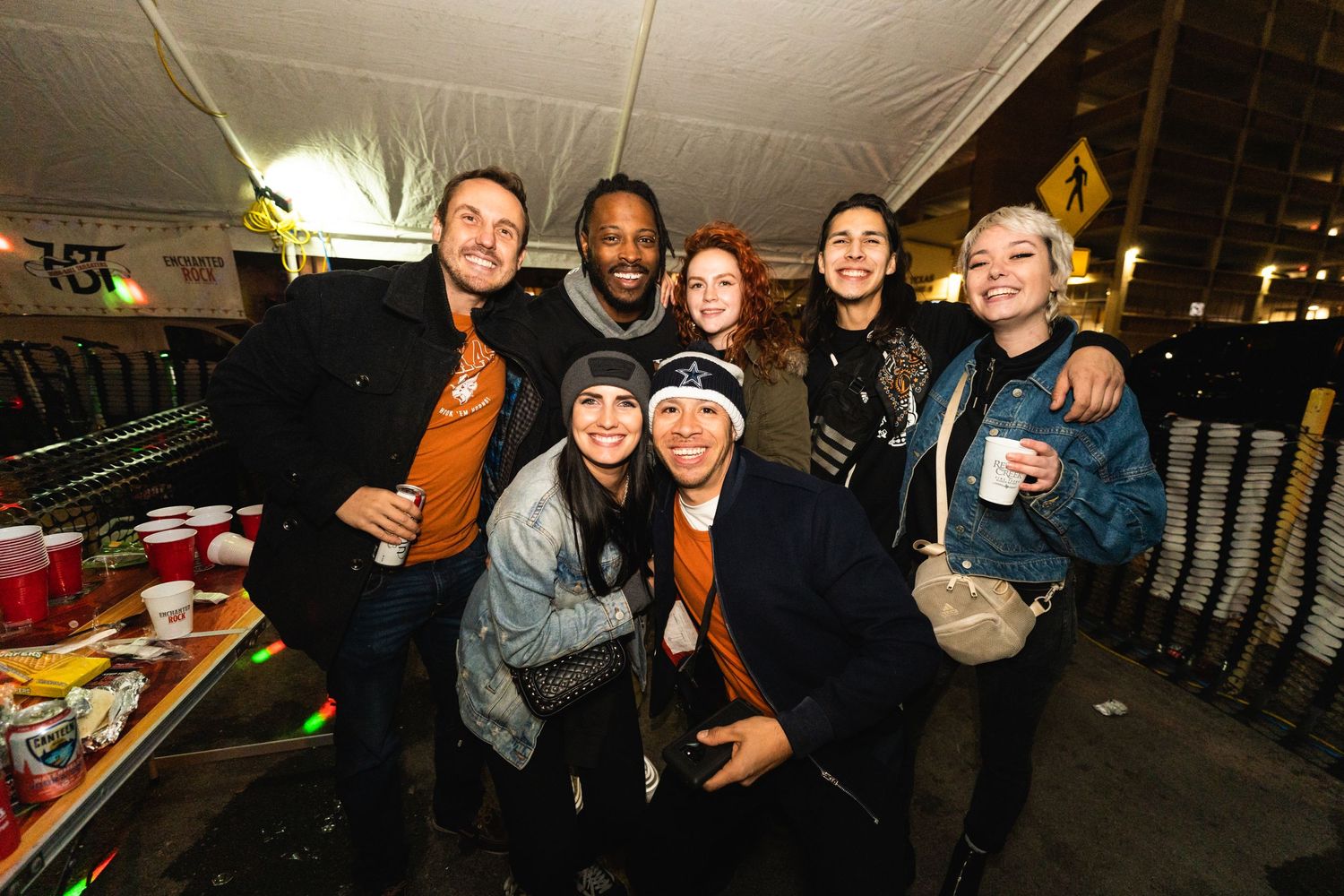 Friends in winter clothing gathered together for a group photo at an outdoor event.