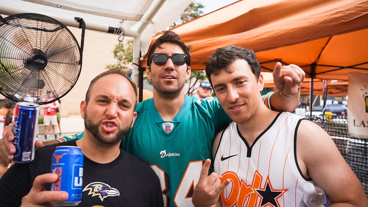 Friends posing with beverages at outdoor sports-themed party.