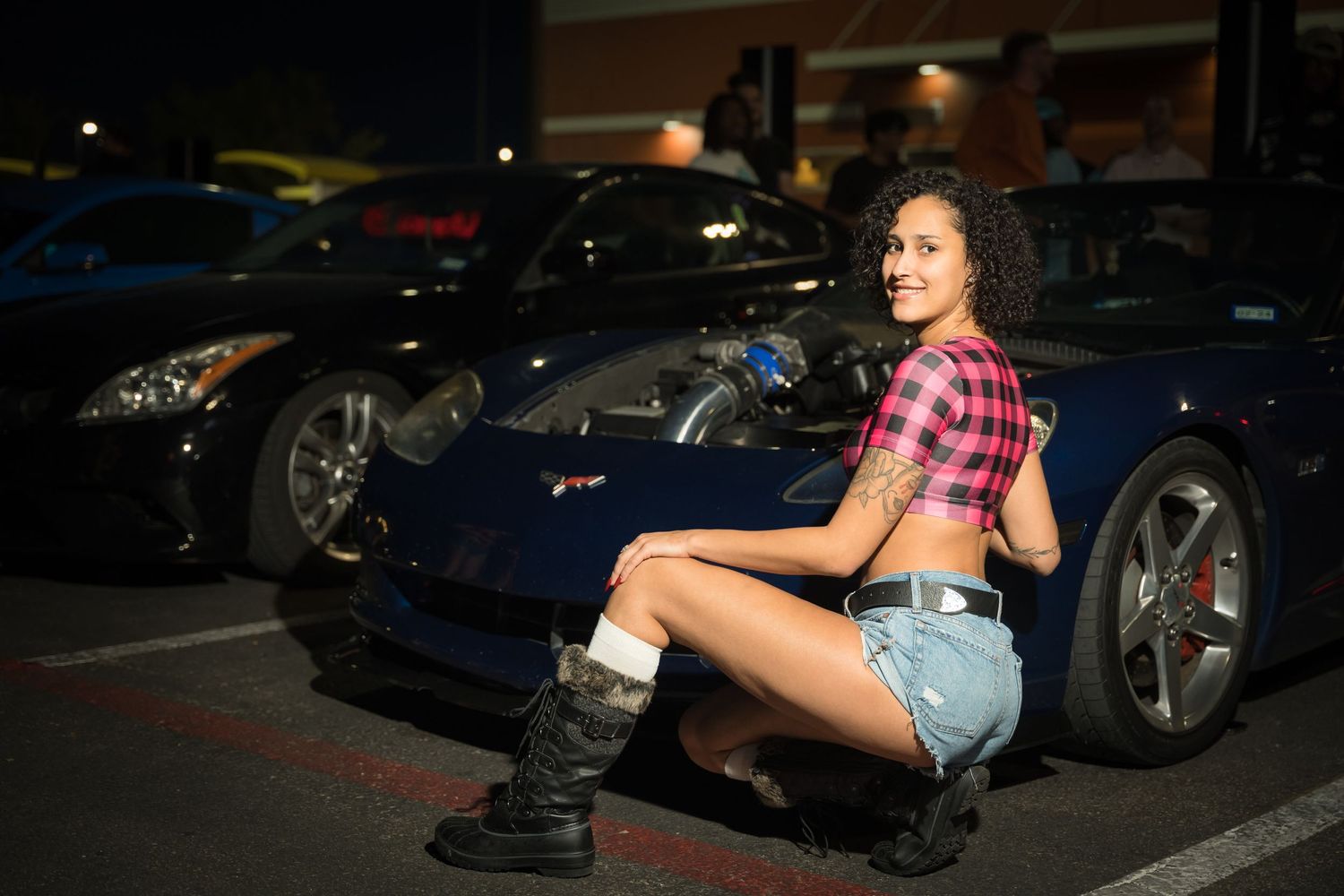 A sports car in a nighttime parking lot setting.