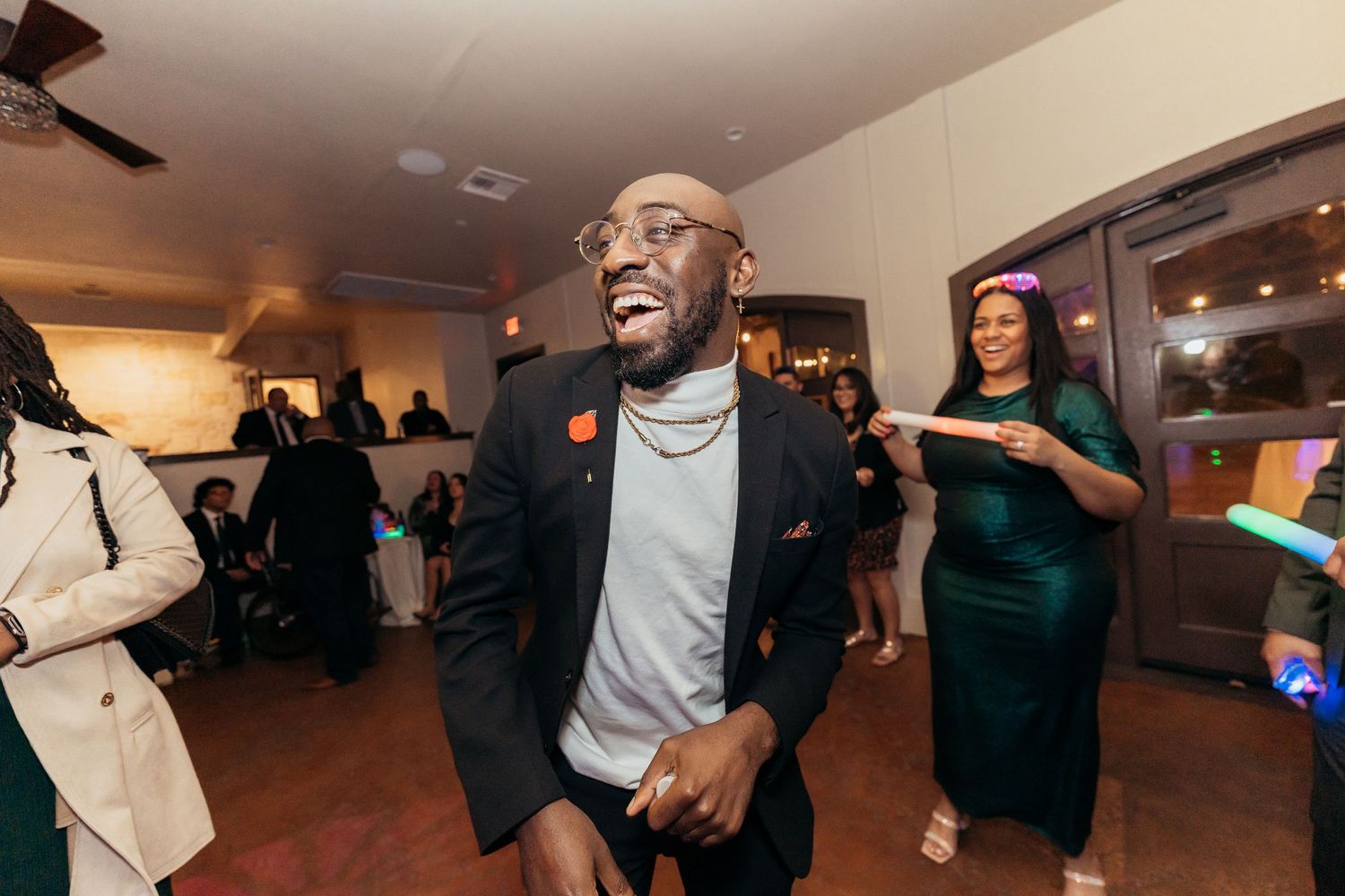 Guests enjoying themselves on a lively dance floor at an indoor celebration.