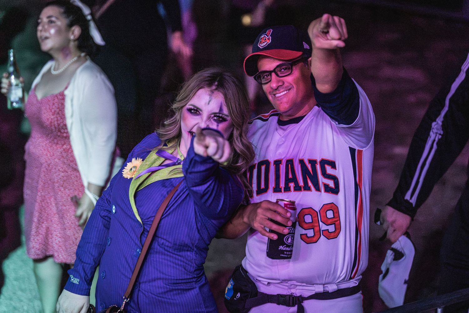 Enthusiastic concertgoers in costume and sports jerseys enjoying a music event.