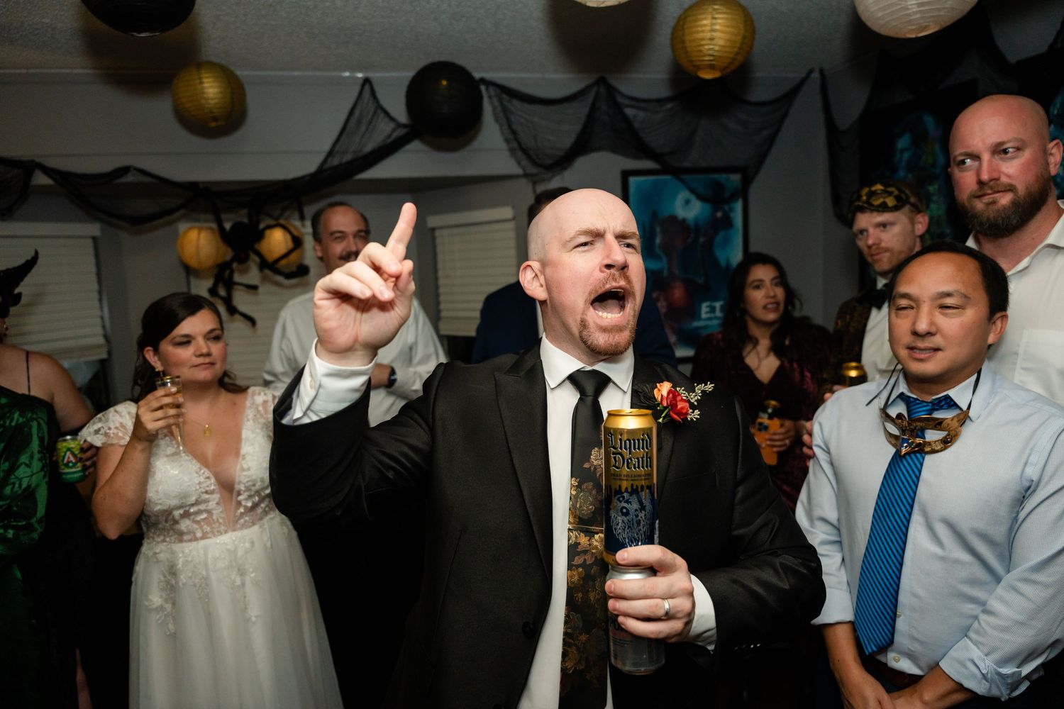 Energetic party moment captured during a wedding reception with black and gold decorations.