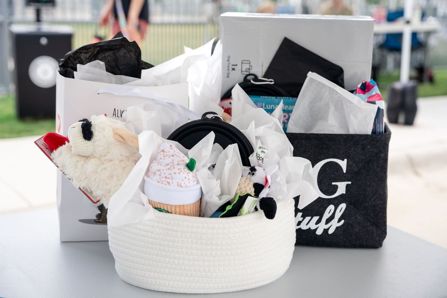 White woven baskets filled with pet supplies and merchandise displayed on a table.