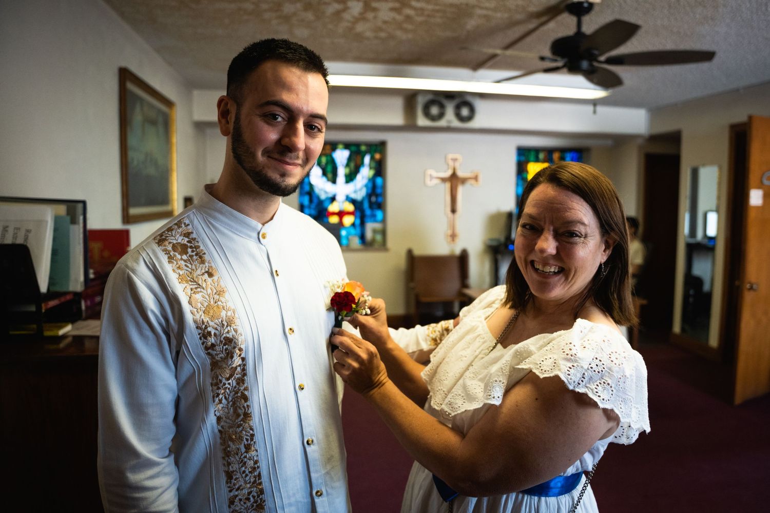 A joyful moment during preparation for a religious ceremony in a church setting.