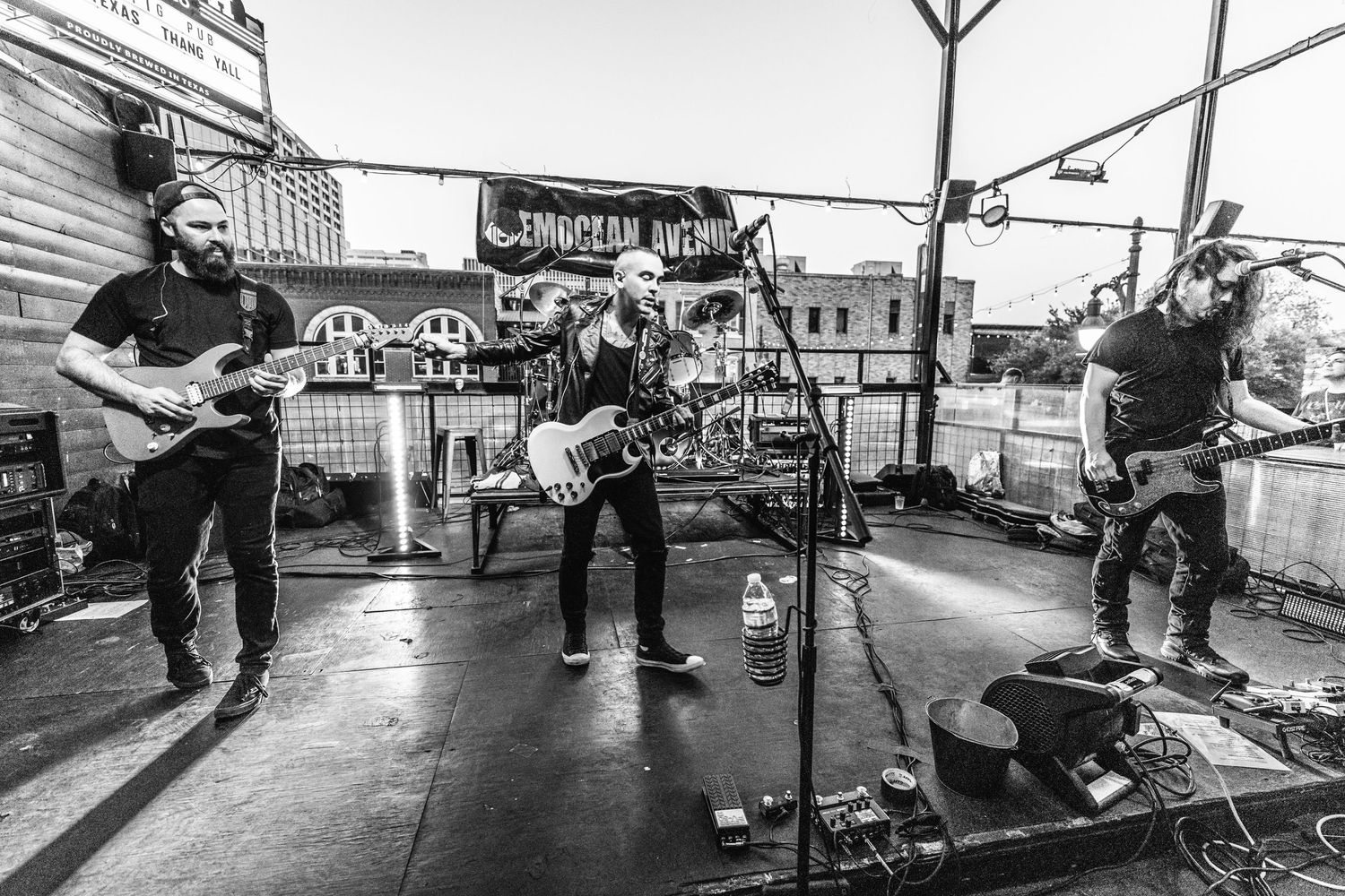 Black and white wide shot of band performing on outdoor stage.