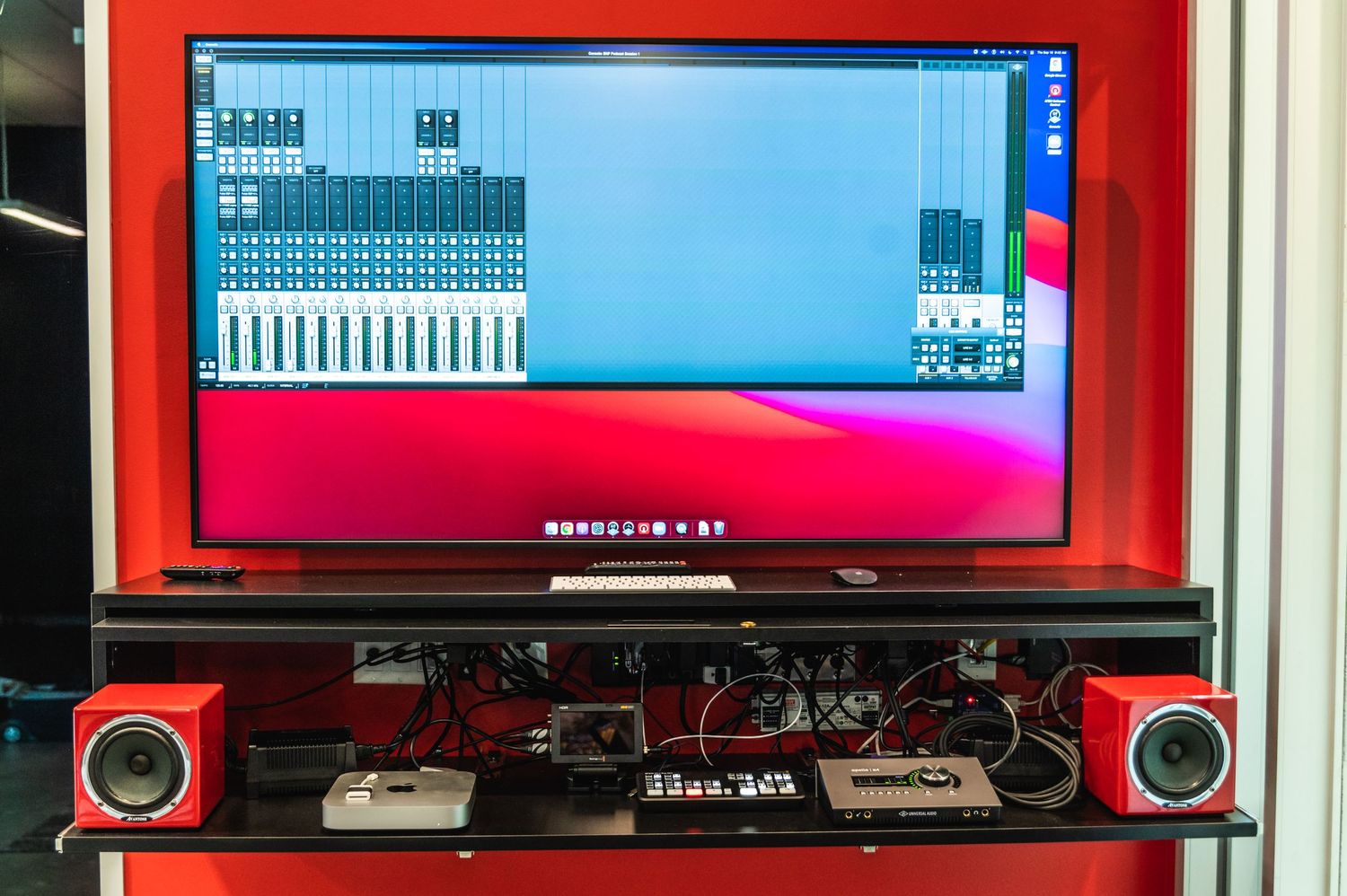 Audio mixing software displayed on red-framed monitor with matching speakers.