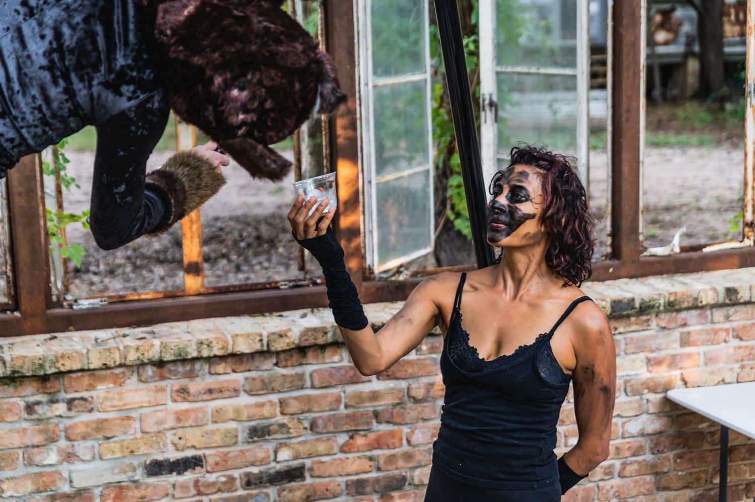 Performers engage in theatrical interaction during aerial arts practice session.