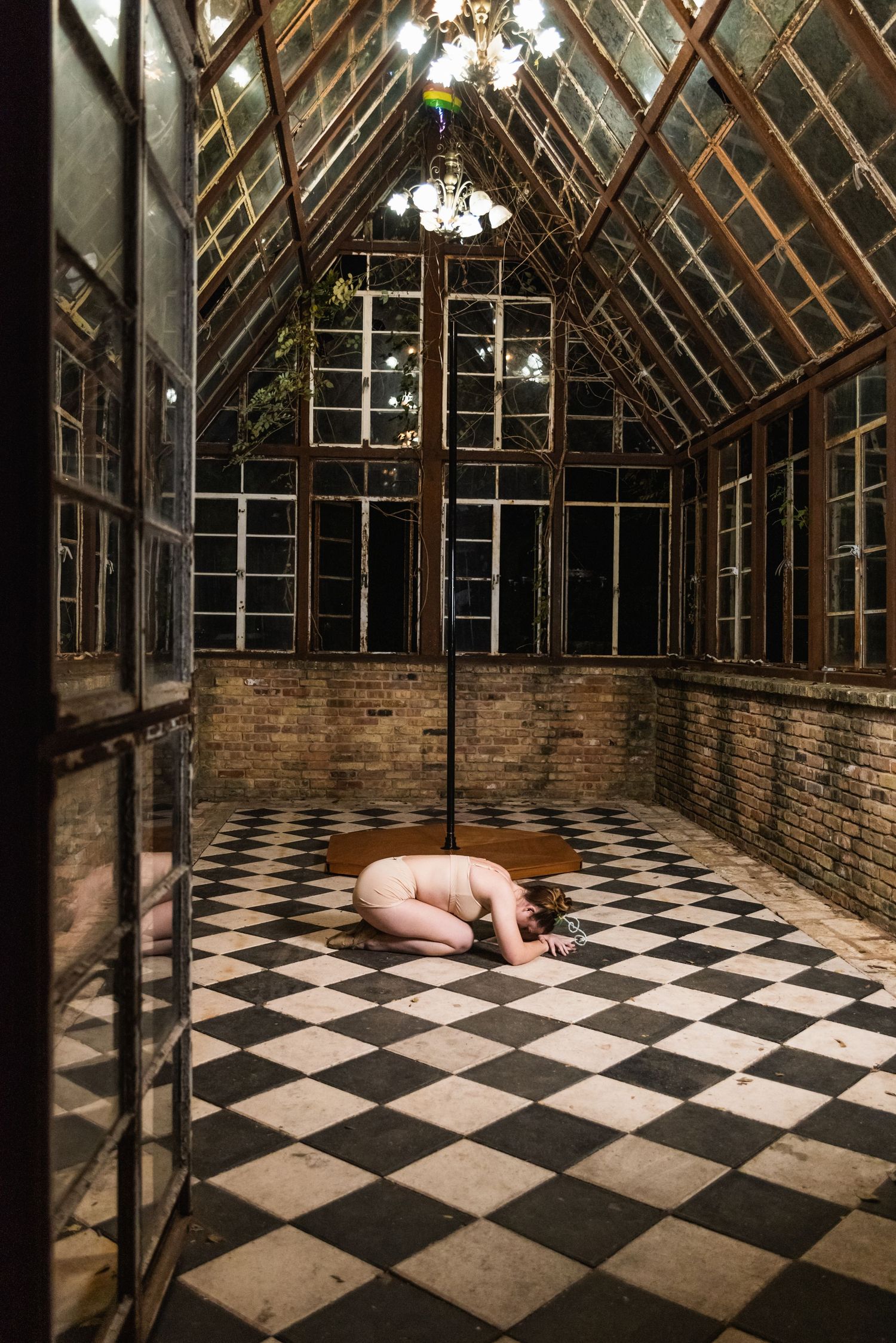 Moody photograph in a glass greenhouse with black and white checkered flooring.
