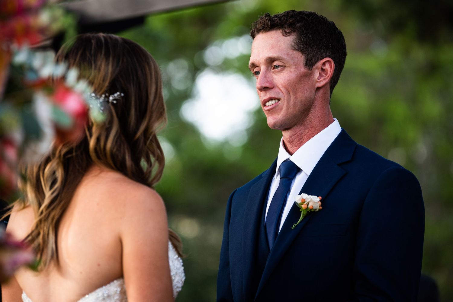 A sweet wedding ceremony exchange between couple under natural lighting.