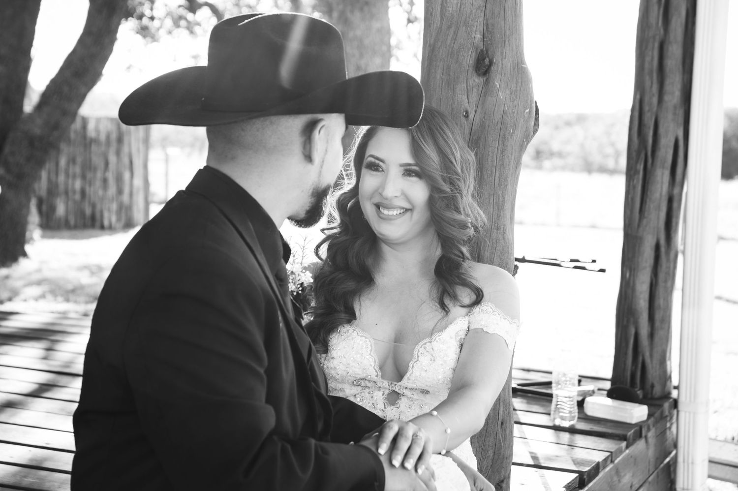 Black and white portrait of couple sharing intimate moment on wooden porch.