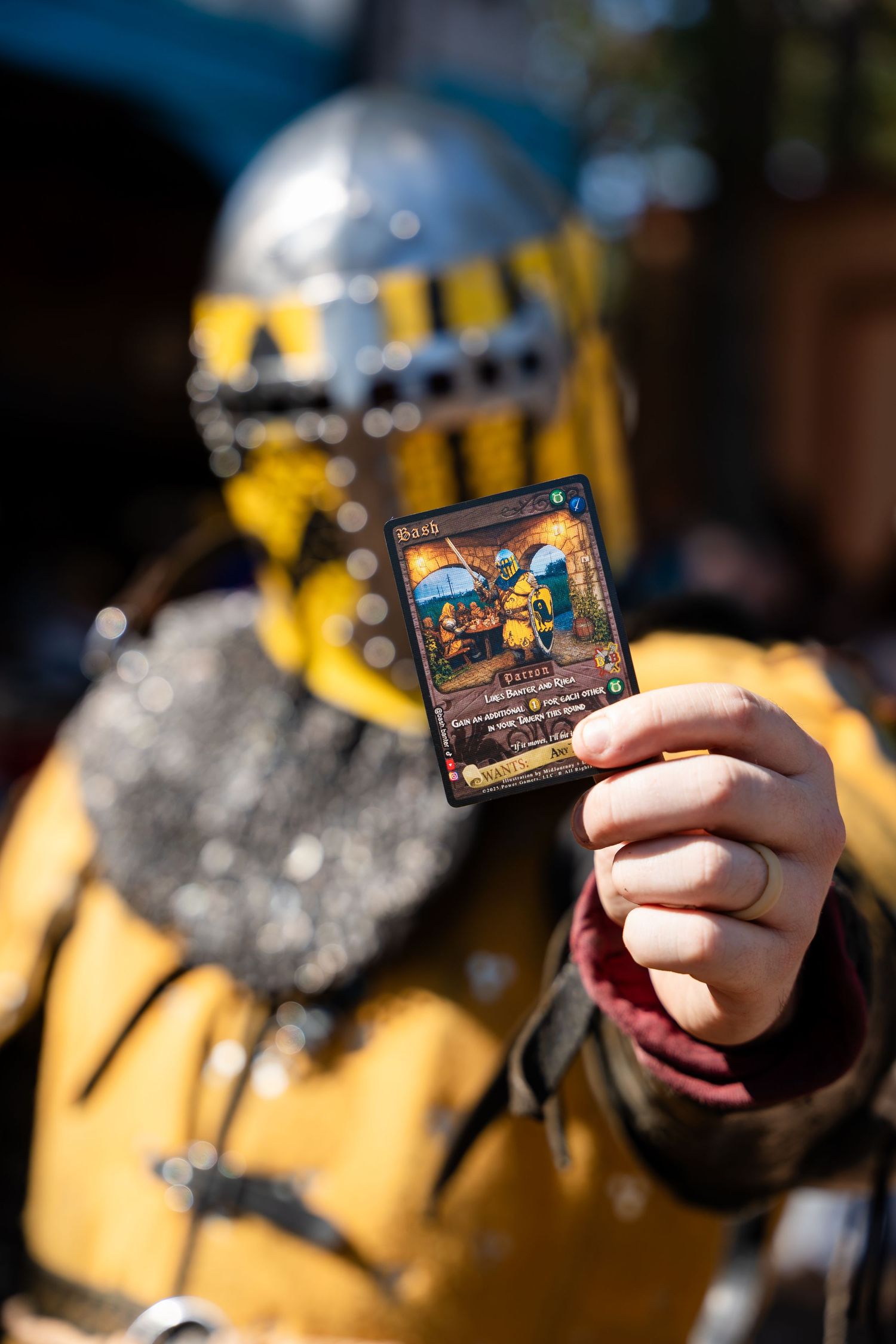 A hand holding up a Disneyland park admission ticket against a blurred yellow and silver background.