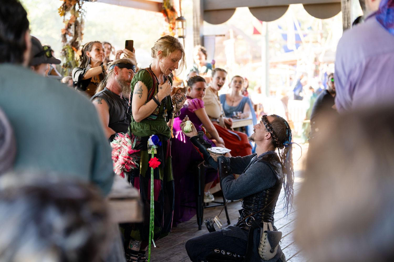Wedding guests celebrate and cheer during an emotional moment at an indoor reception ceremony.