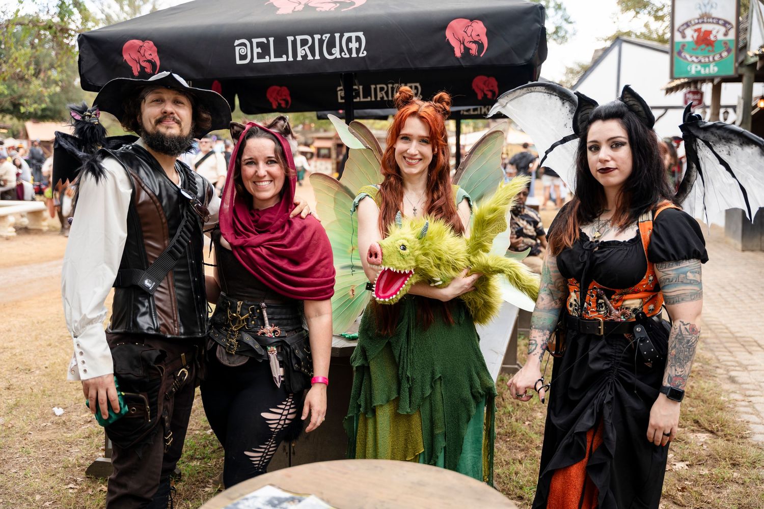 Group of cosplayers in medieval and fantasy costumes posing together at a renaissance festival event.