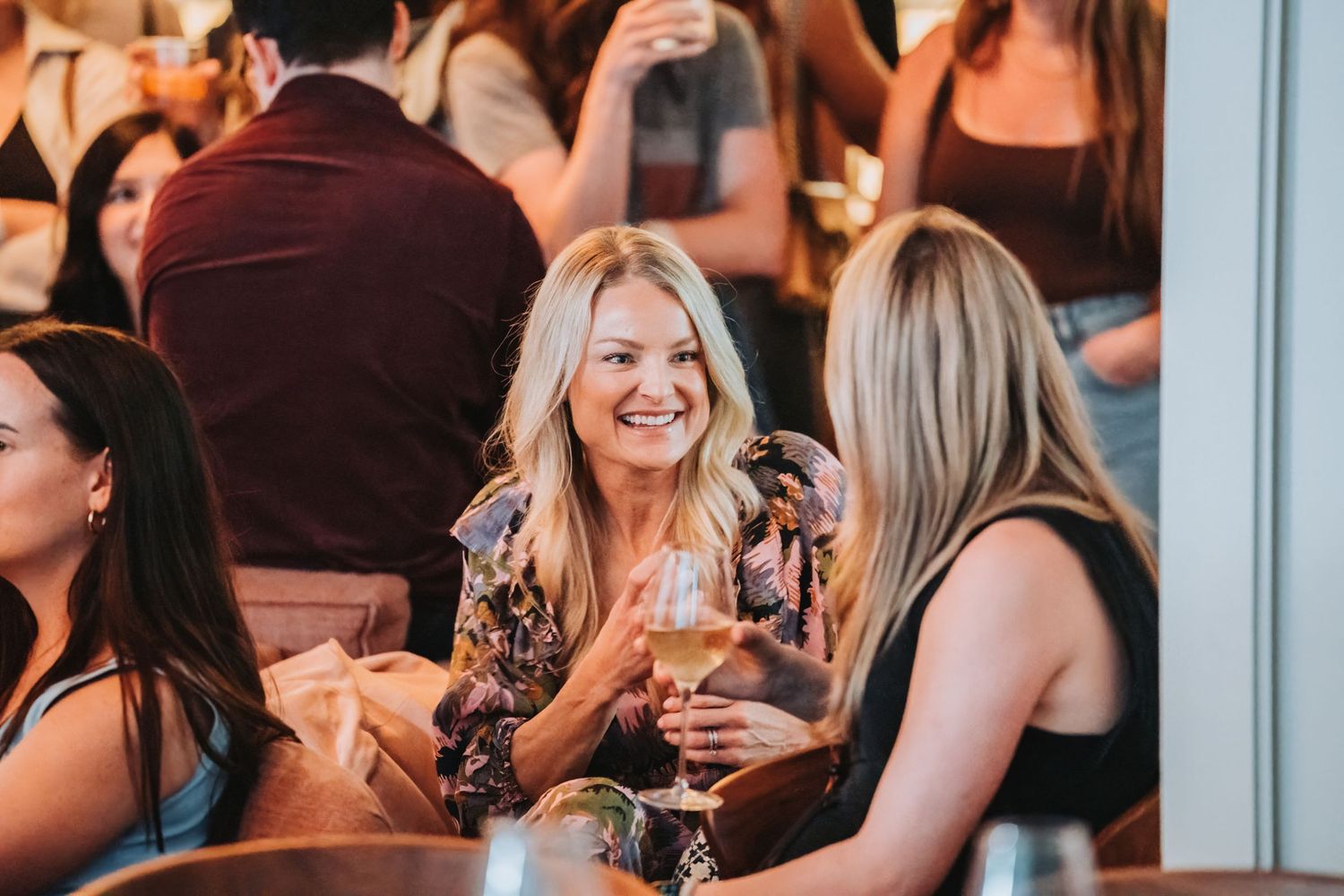 People enjoying drinks and socializing at a lively bar or restaurant gathering.