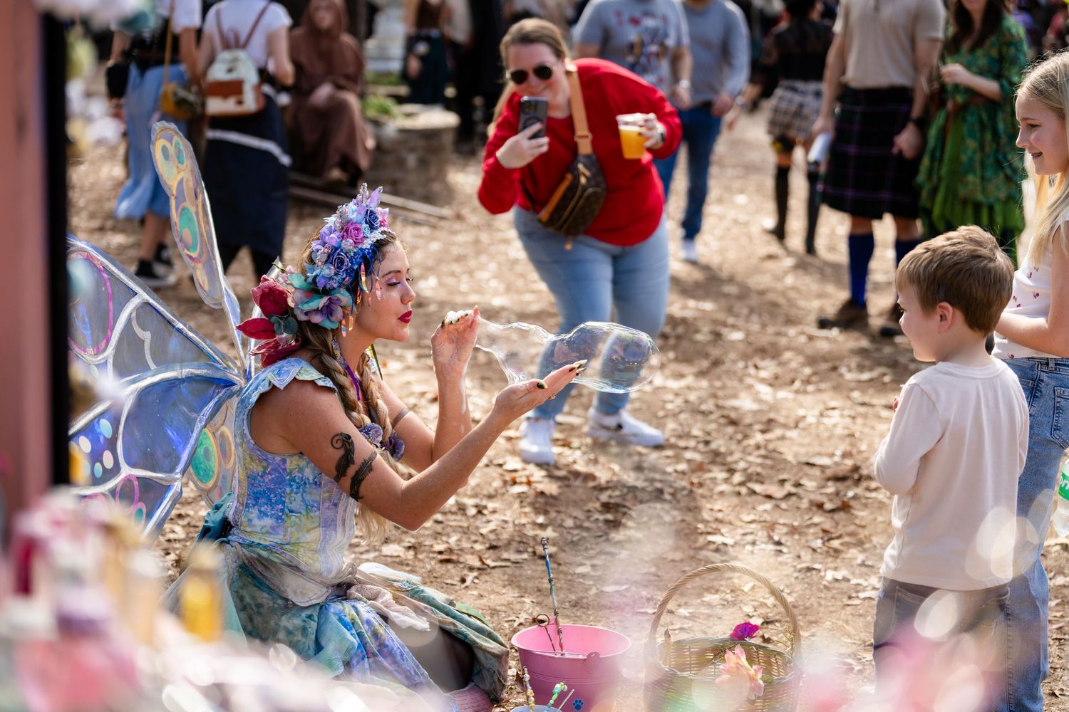 People enjoying a festive celebration outdoors with bubbles and confetti in a natural setting.