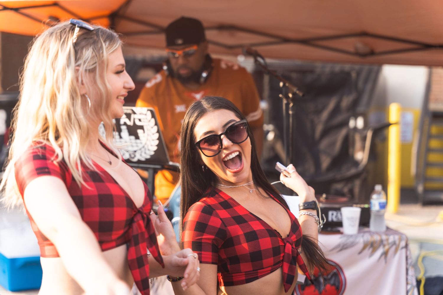 Festive outdoor party scene with people in matching plaid outfits enjoying themselves.