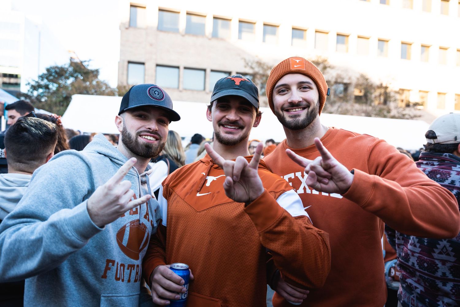 Three sports fans pose together at a tailgate party.
