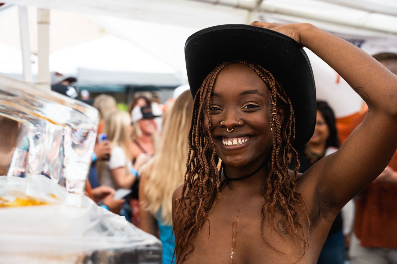 Person wearing a black hat and smiling while at an outdoor party.