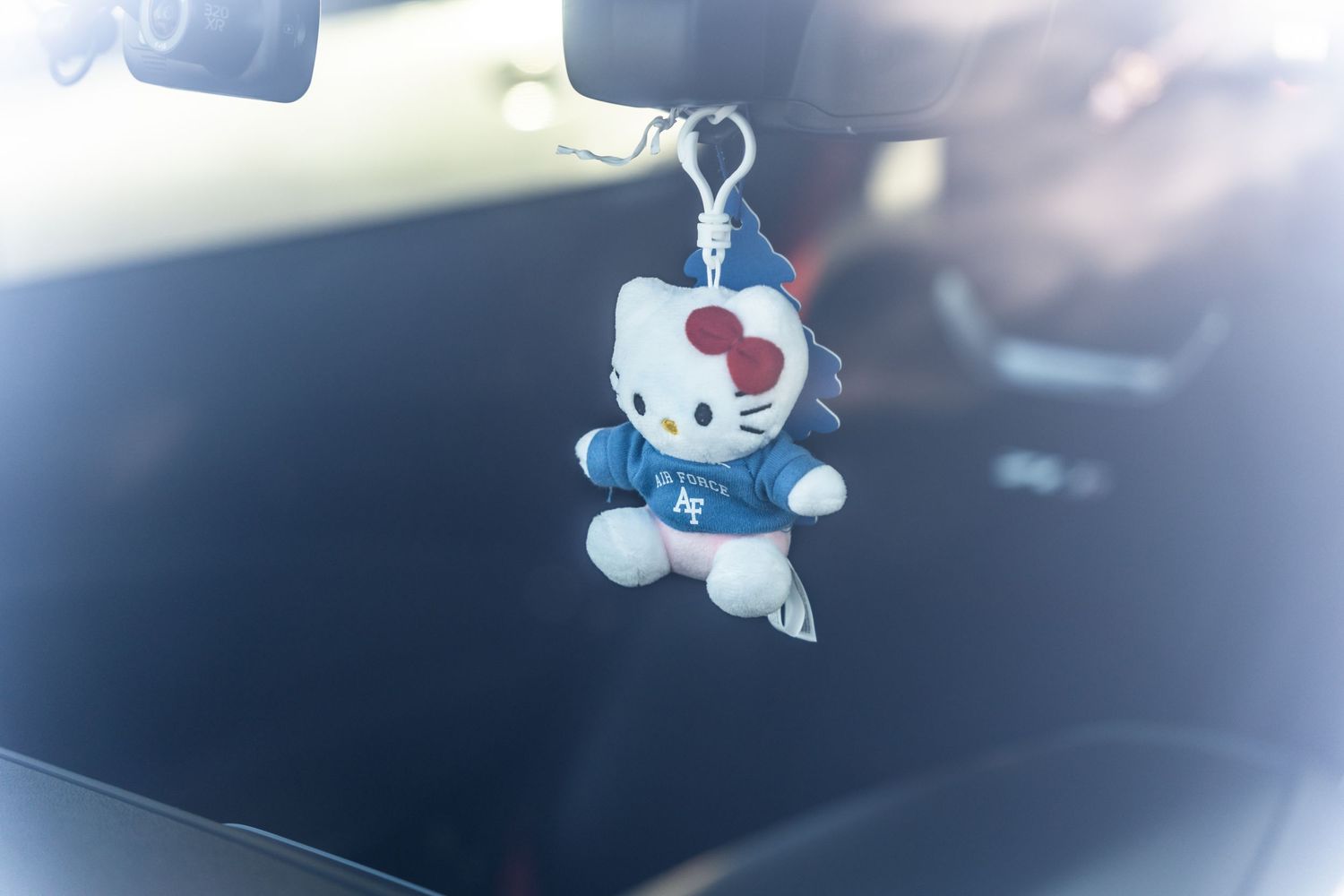 Hello Kitty plush doll hanging from a car rearview mirror as an accessory.