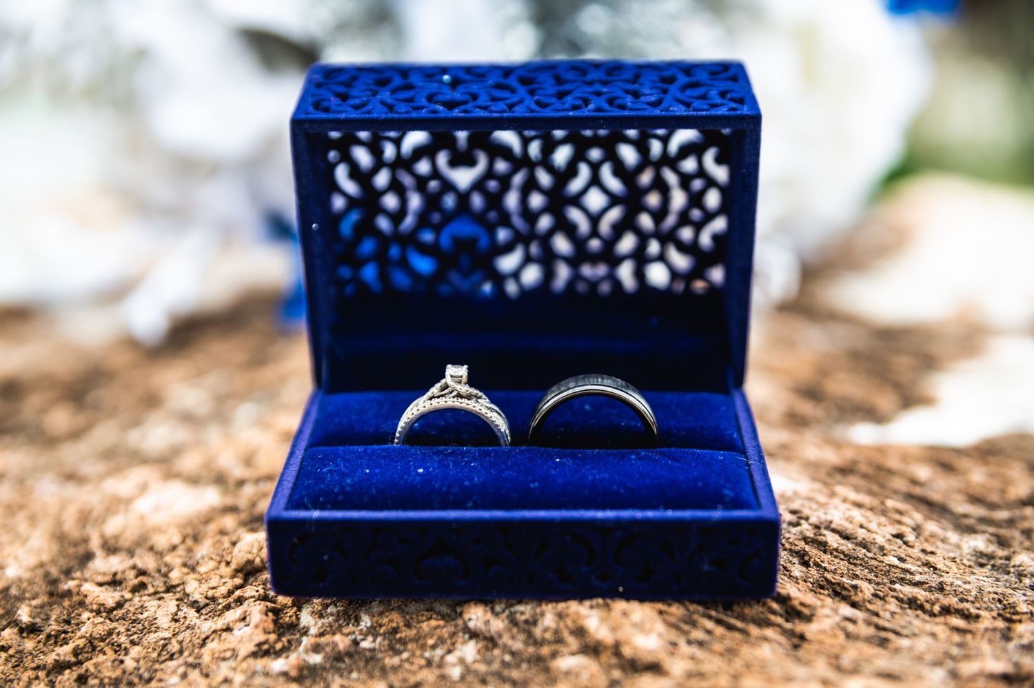 Wedding rings nestled in a decorative blue velvet ring box.
