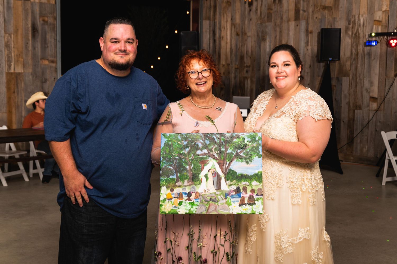 A group displays artwork in a rustic barn venue during a special event.