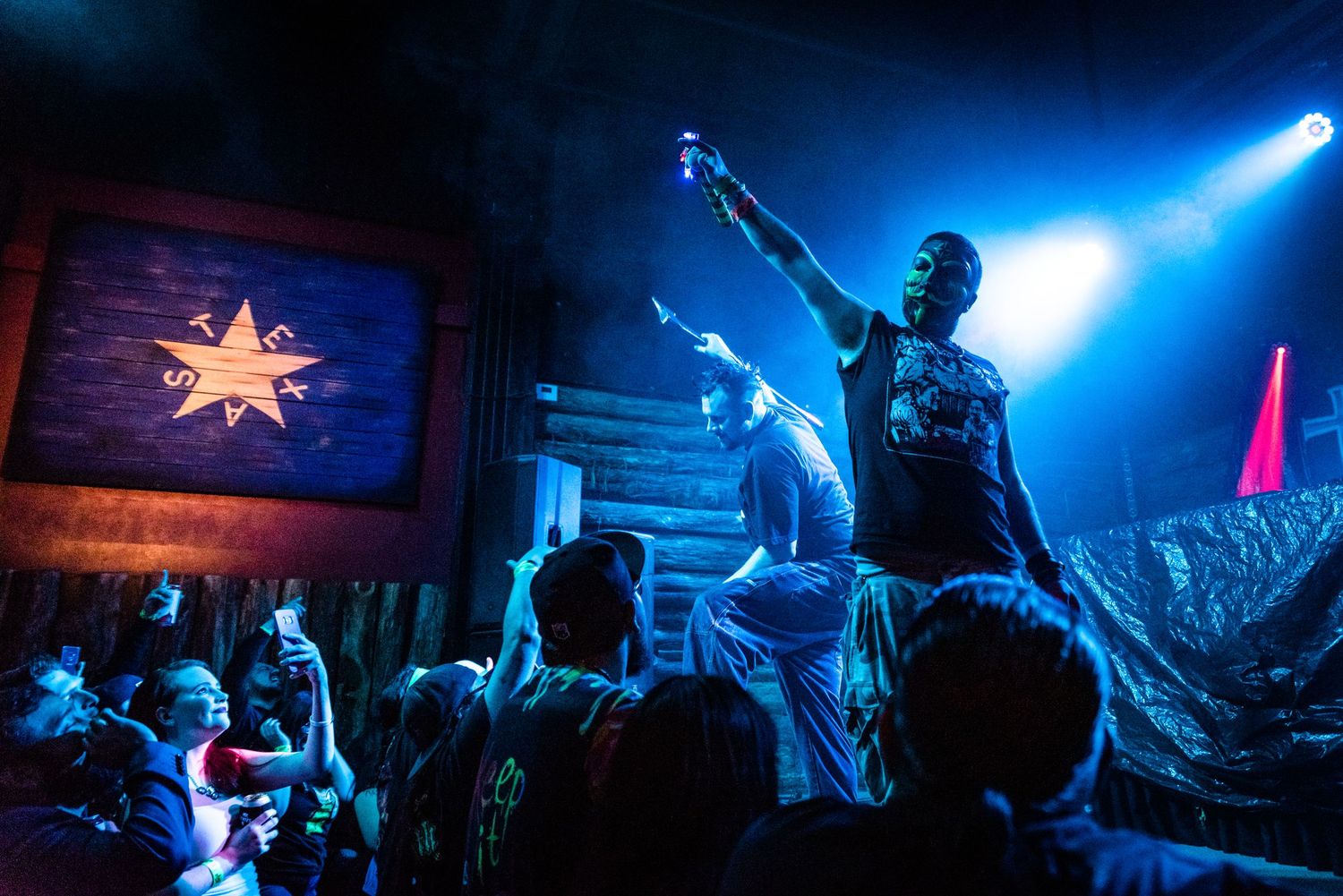 Concert performer on stage with blue lighting and star decoration in background.