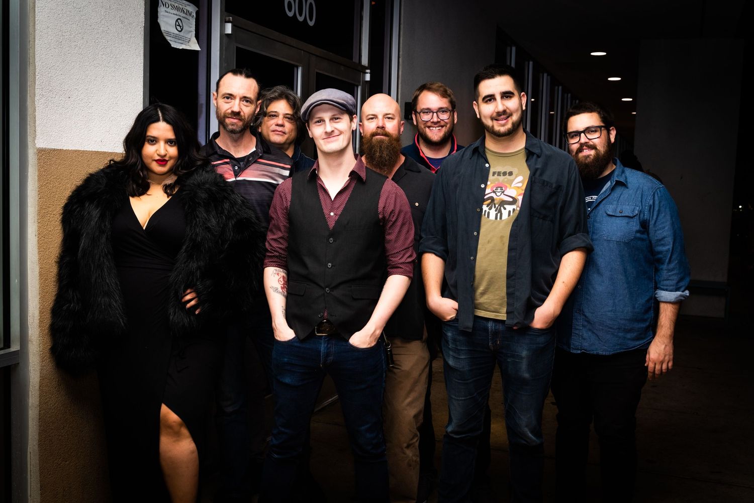 Group portrait of band members in a hallway.