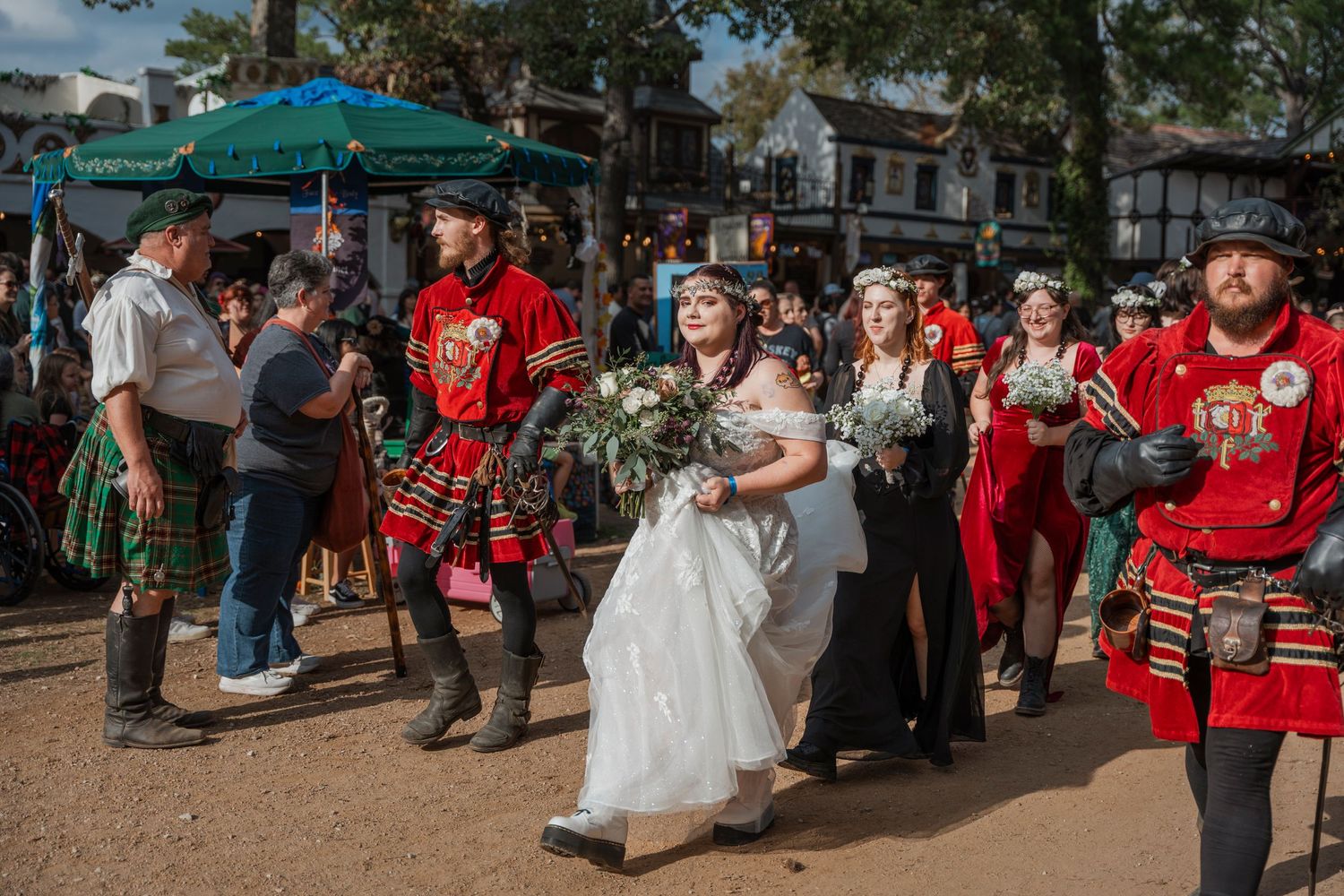 A renaissance festival wedding scene with performers in period costumes and kilts.