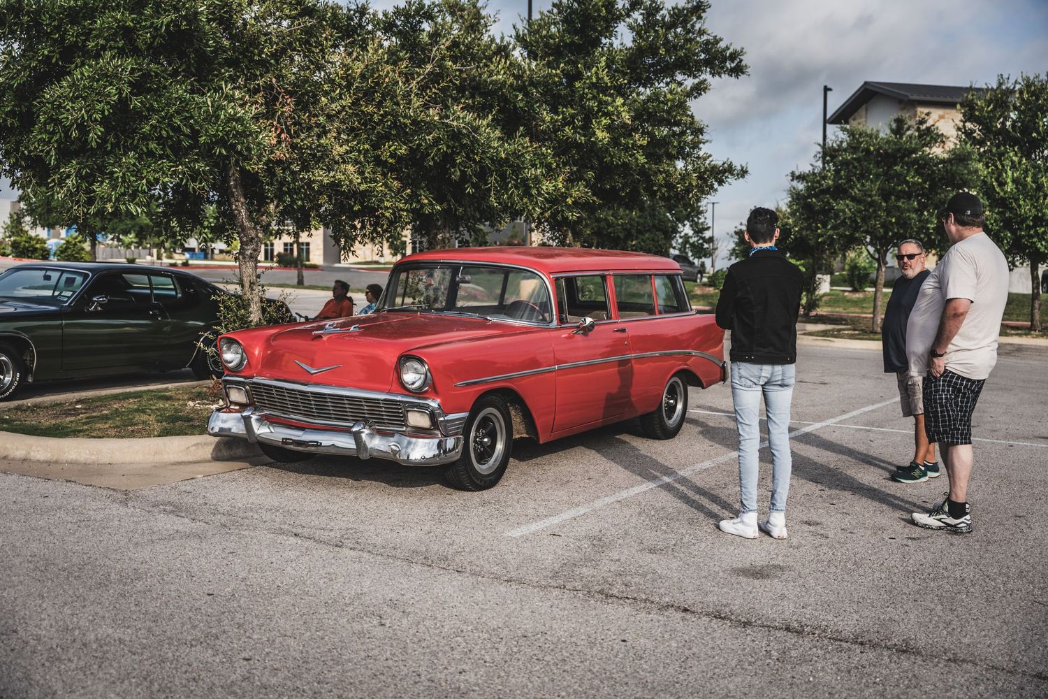 Classic red 1950s Chevrolet wagon on display at a car meet.