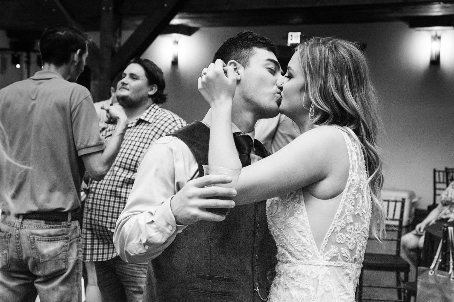 Romantic moment shared between couple during wedding reception in black and white.