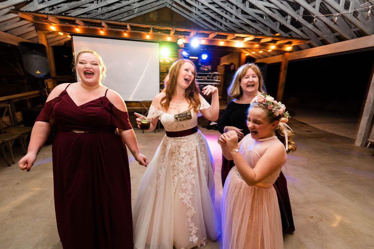 Wedding party members dancing and celebrating at an indoor reception.