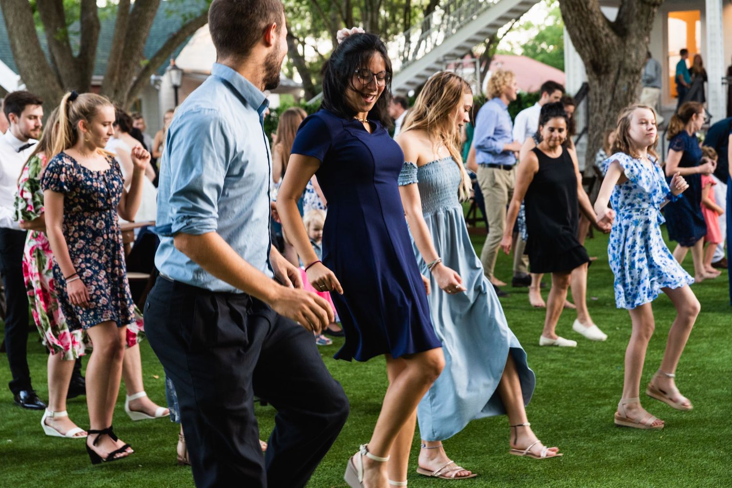 Party guests dancing on a lawn during a festive outdoor celebration.