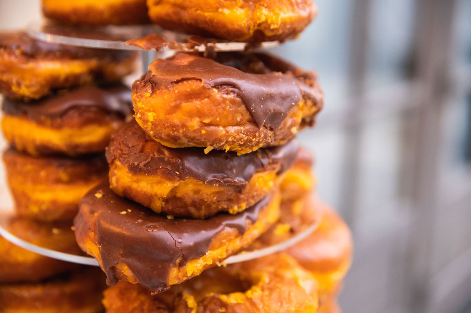 Stack of chocolate-dipped pastries or donuts arranged in layers on a display.