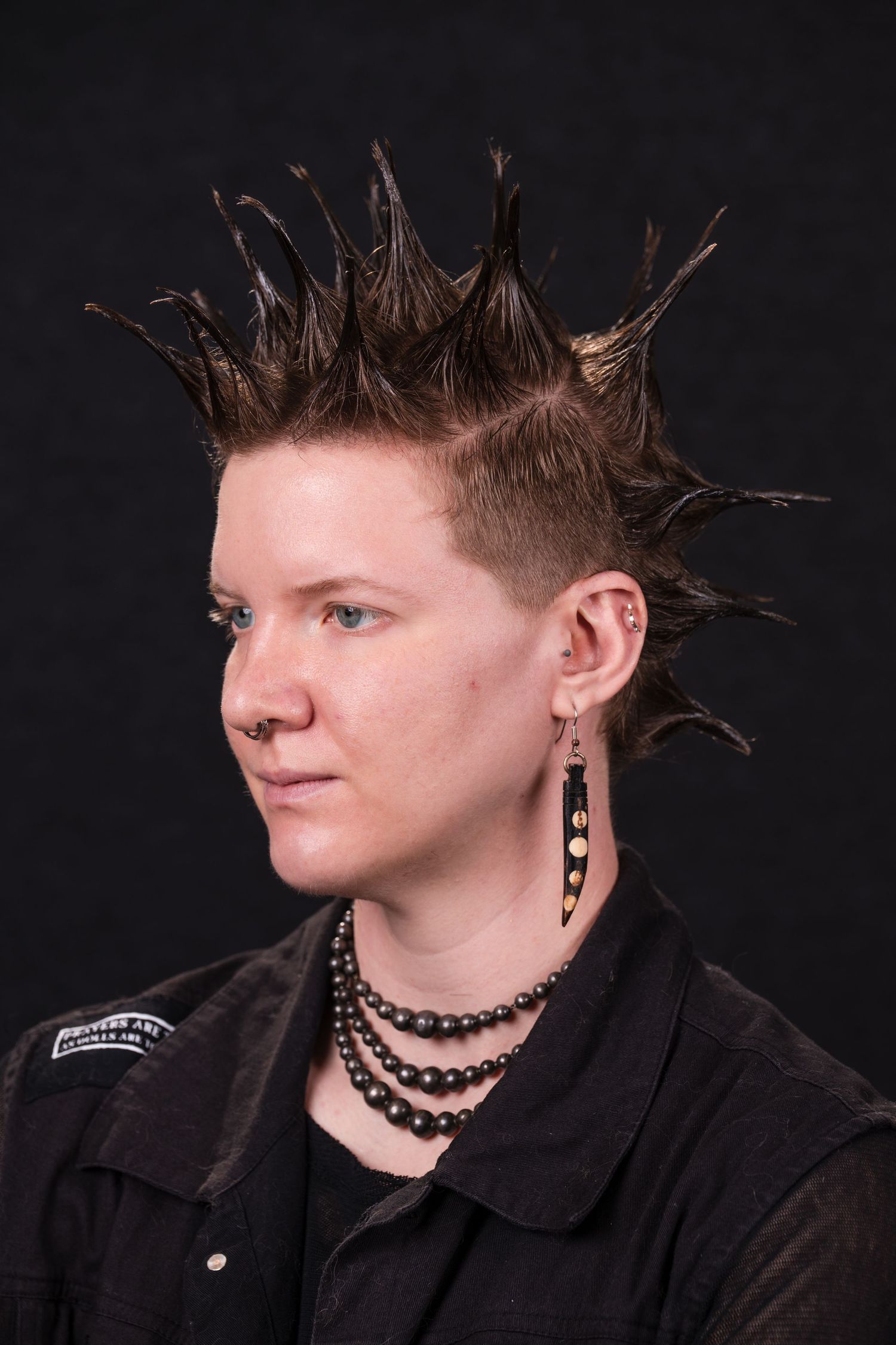 Profile photo series against black background showing different angles of person wearing black shirt and chain necklace.