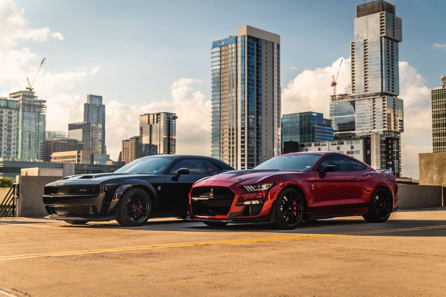 A panoramic lineup of luxury sports cars parked against a cityscape backdrop with modern skyscrapers.