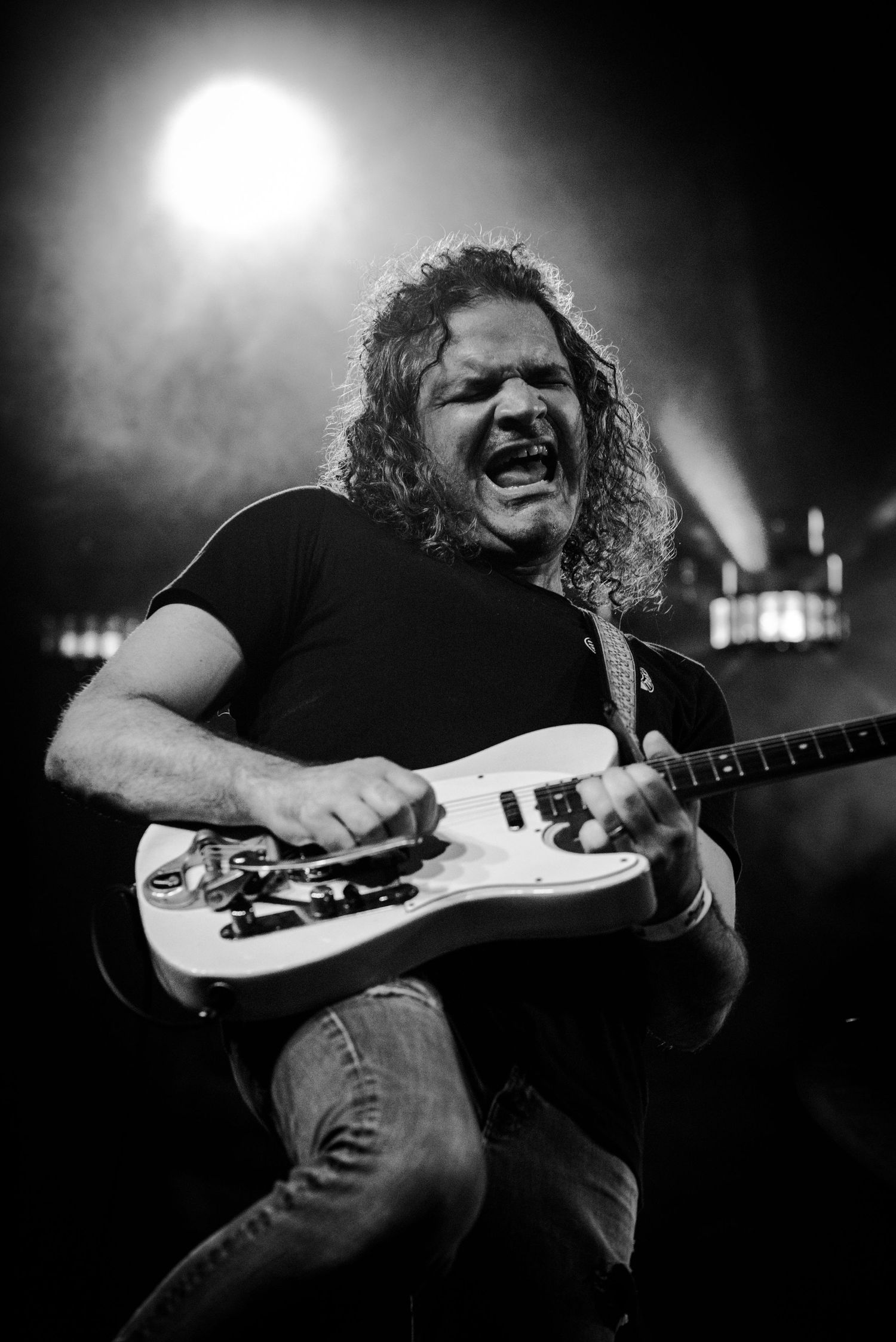 A dramatic black and white sequence of a guitarist performing on stage with intense emotion and passion under spotlights.