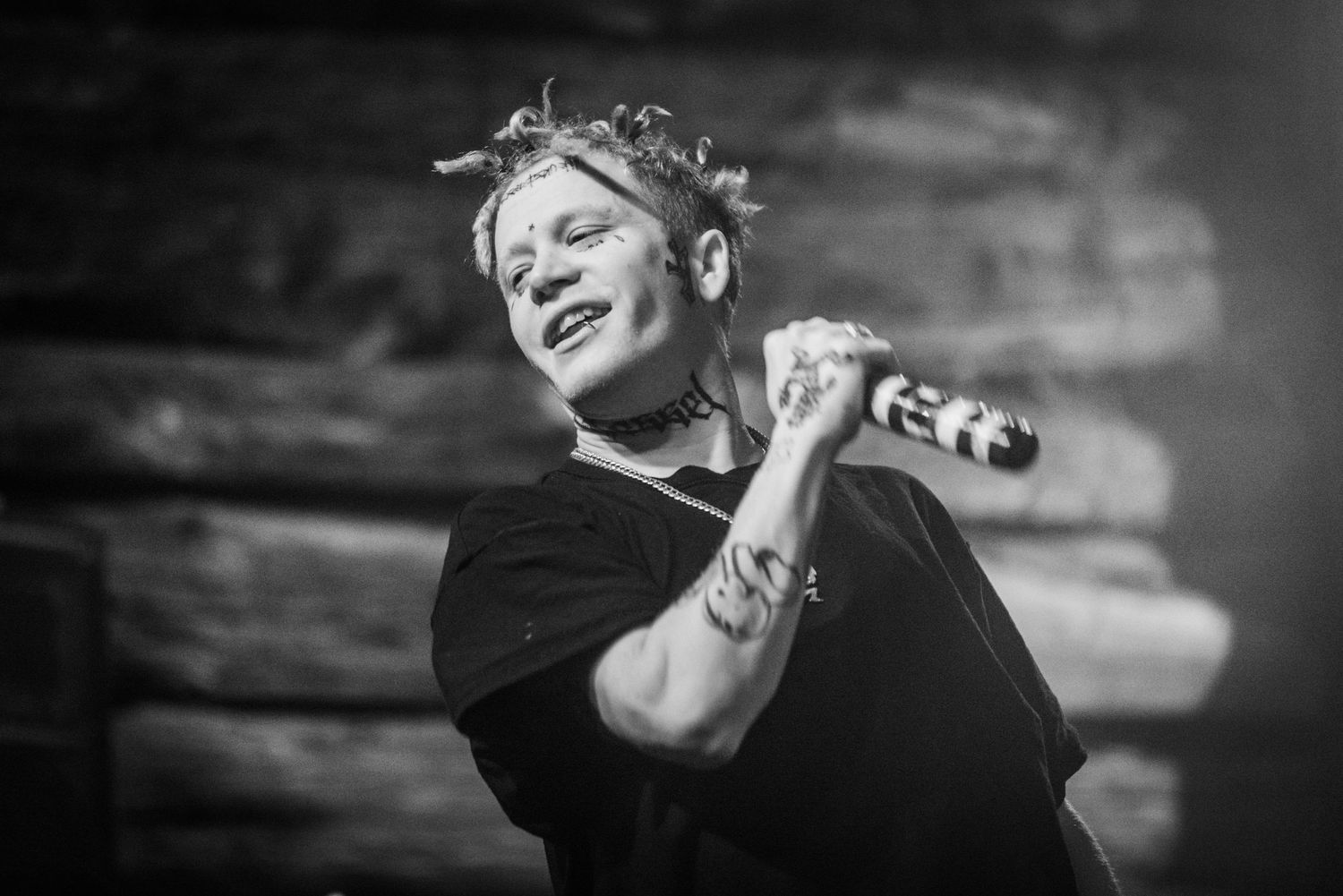 Black and white image of performer singing into microphone during concert.