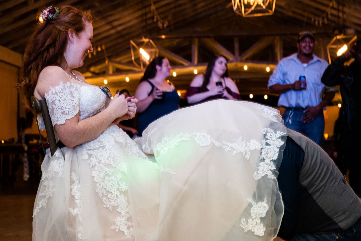 Dancing and celebration at a wedding reception under decorative lighting.