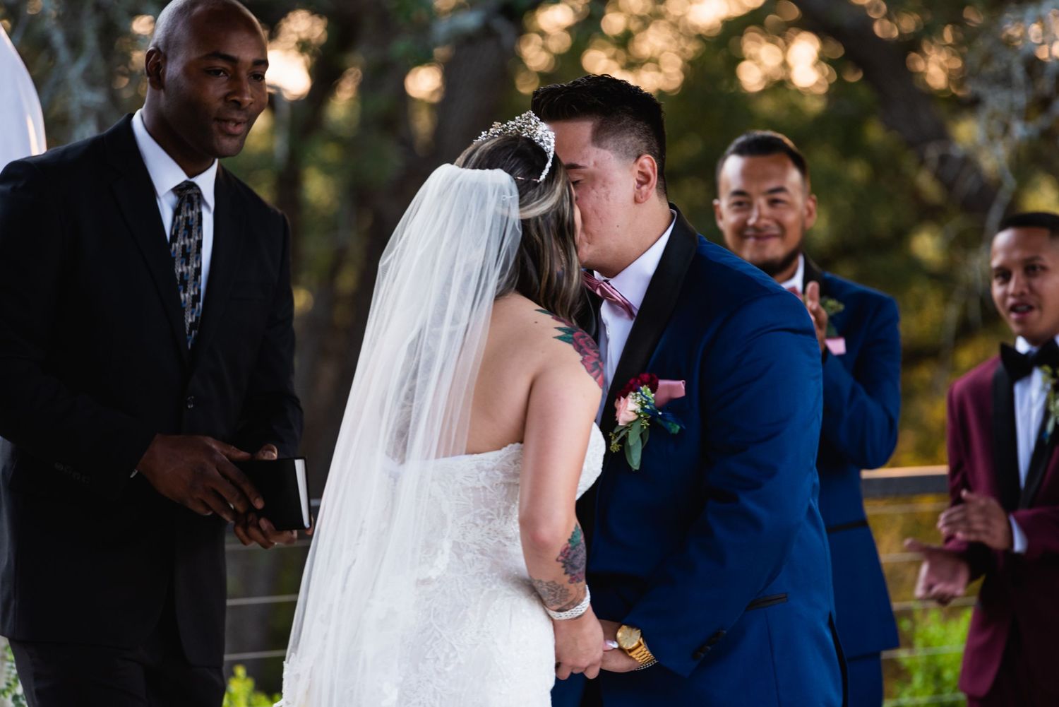 An intimate moment during a wedding ceremony with attendees looking on.