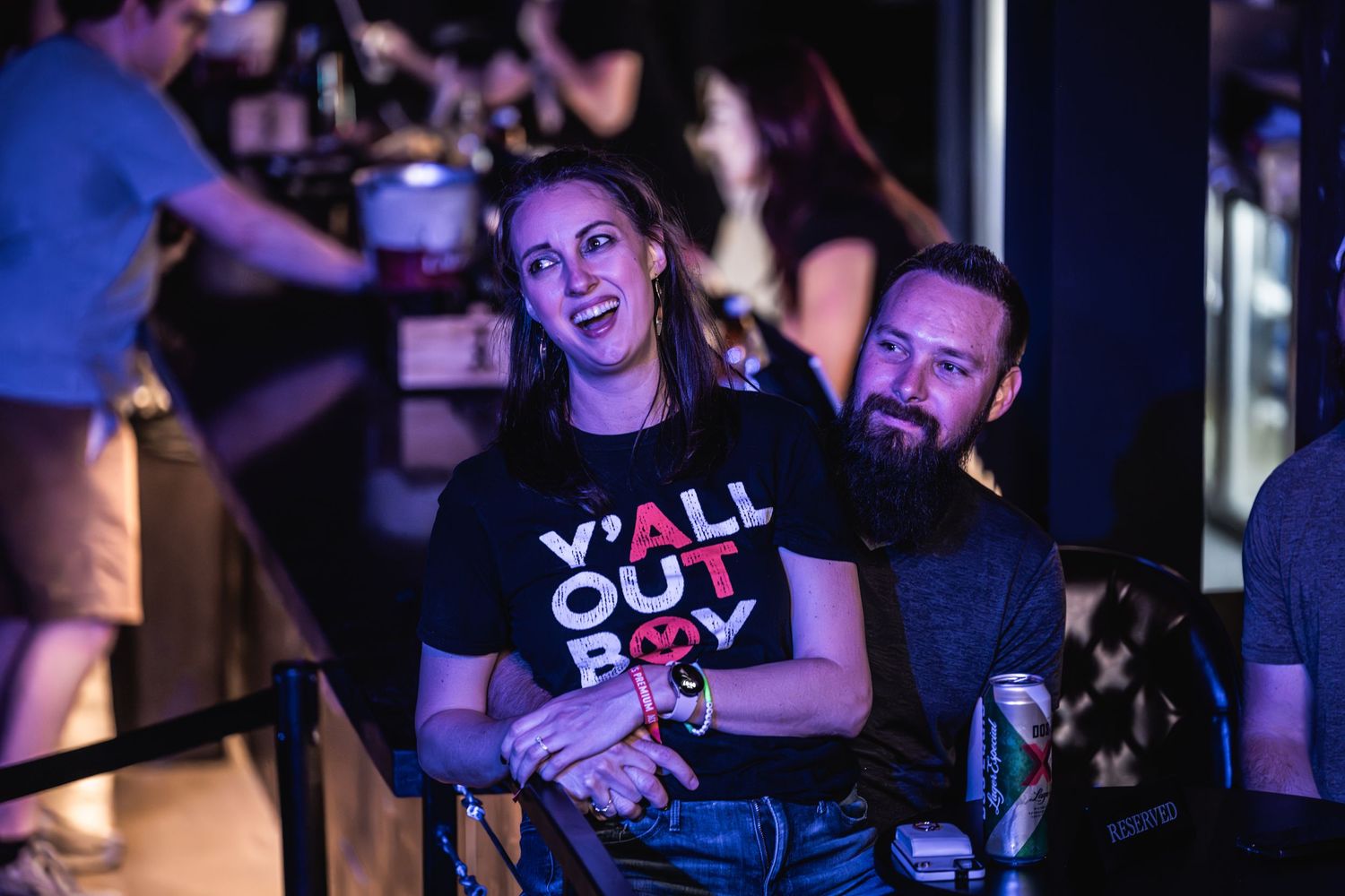 Concert attendees enjoying show under blue stage lighting at music venue.