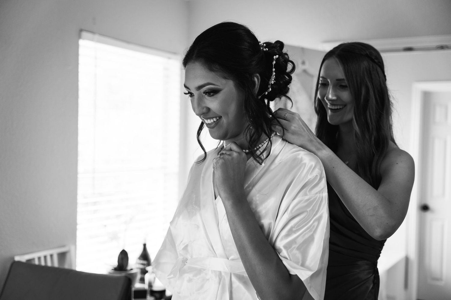 A black and white photograph captures getting ready preparations on a wedding day.