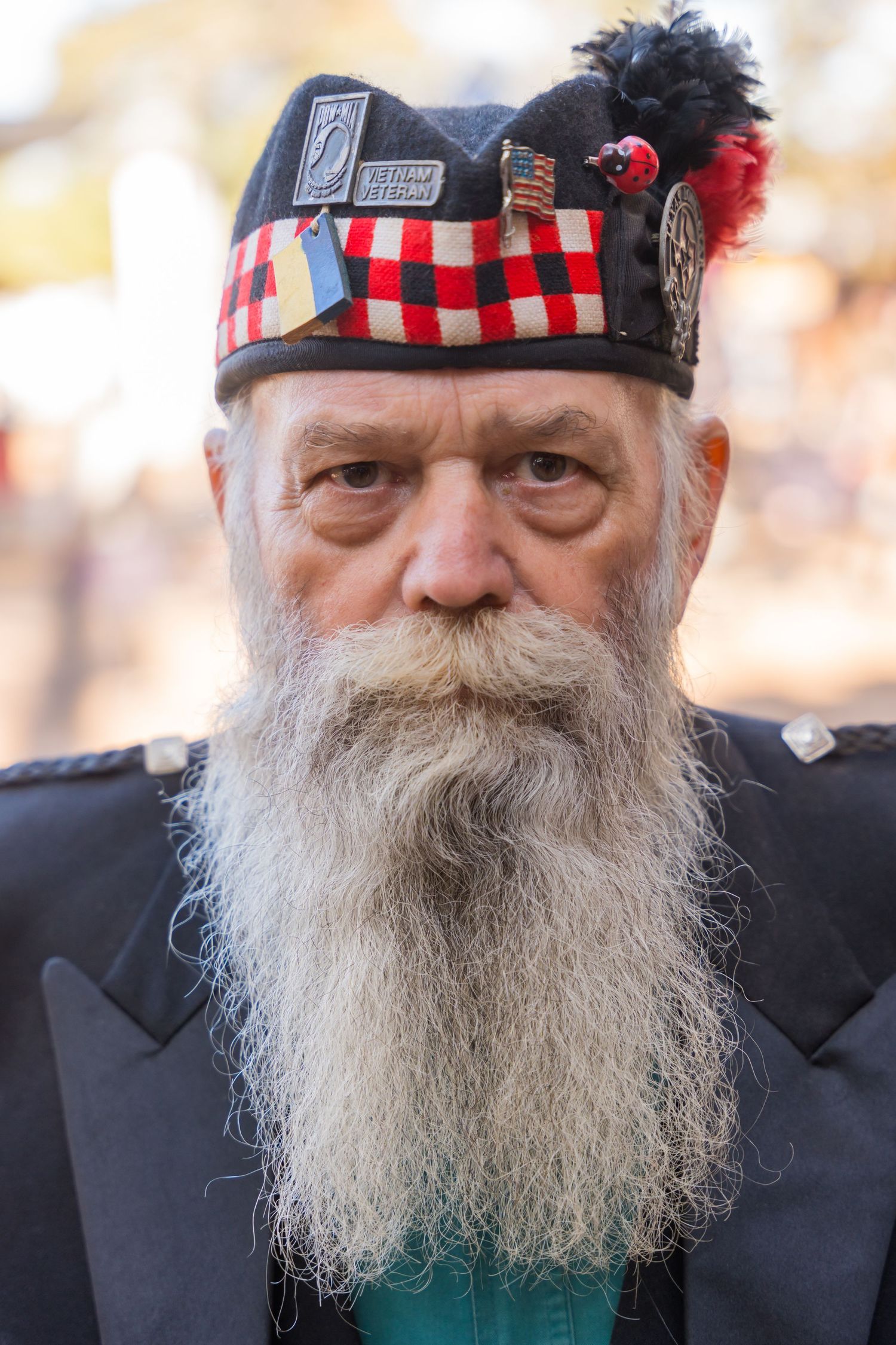 Person wearing a traditional Scottish hat with checkerboard pattern and feather plume.