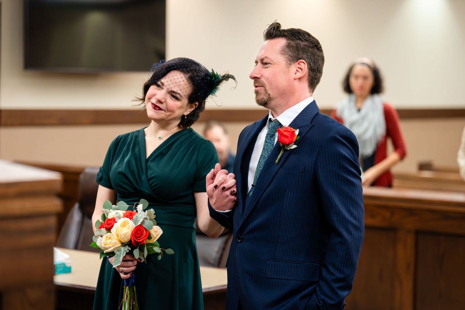 A couple shares laughter during their civil wedding ceremony in a courthouse.