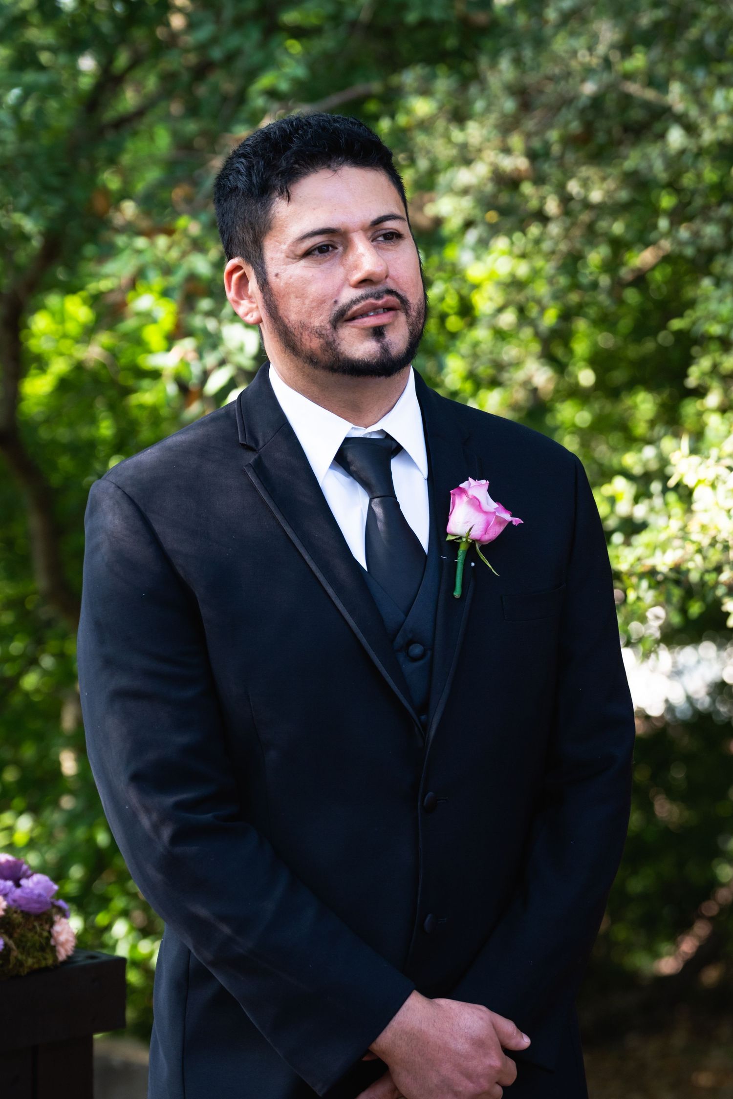 A formal portrait at a wedding ceremony with natural garden backdrop.
